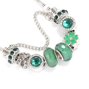 Detail of green beaded bracelet featuring faceted crystal and enamel clover pendant charm