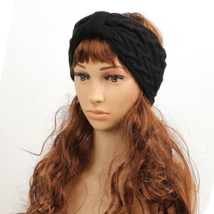 Close-up of black cable-knit headband with twist design for winter warmth and style