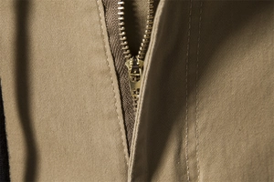 Detail of high-quality gold metal zipper on khaki twill cotton cargo trousers