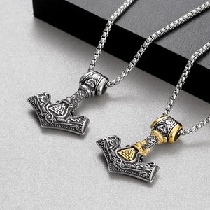 Macro view of Viking Mjolnir pendants in silver and two-tone gold on box chains