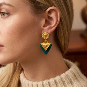 Vintage gold relief Dreieck Ohrringe mit smaragdgrünen Akzenten an einem eleganten Model