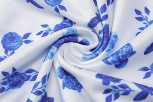 Detailed macro view of white fabric with blue floral patterns and smooth drape texture