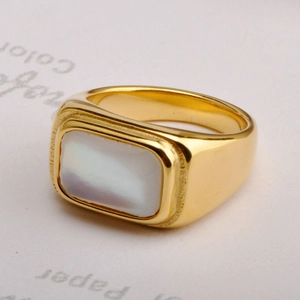 Close-up of gold signet ring with rectangular white shell inlay and polished finish