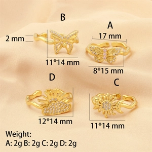 Detail view of four 18K gold plated zircon butterfly and sun open rings on silk