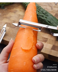 Detail showing the stainless steel peeler blade shredding a carrot on a wooden board