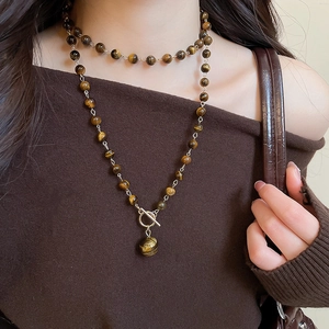 Dettaglio della collana di perle occhio di tigre con chiusura a T e pendente tondo