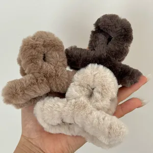 Macro view of plush cross-over hair claw clips in brown, coffee, and beige fuzzy fabric