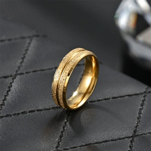 Macro detail of gold titanium steel ring with frosted texture on black leather pad