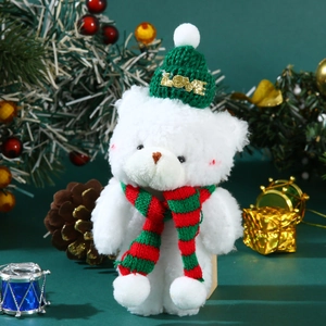 Close-up of white plush bear wearing a green LOVE hat and striped scarf for Christmas