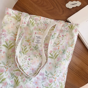 Détail du sac cabas en coton fleuri avec imprimé vintage et étiquette sur table en bois