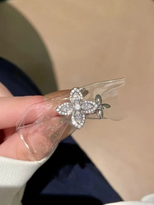 Macro detail of silver flower ring with white zircon stones held in hand close-up