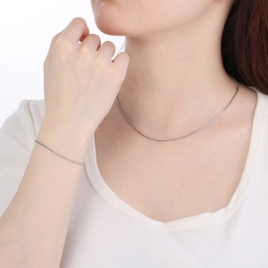 Adjustable silver titanium steel necklace and bracelet set shown on a model