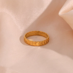 Detail of 18K gold plated stainless steel ring with textured fish scale pattern on silk