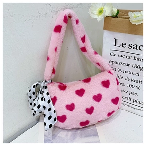 Close-up of a pink plush faux fur handbag with red heart patterns and a polka dot scarf