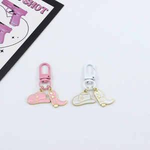 Detail showing cowboy hat and boot charms on pink and white enamel western keychains