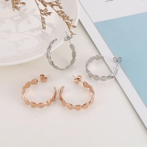 Detail view of heart-shaped hoop earrings in silver and rose gold polished finishes