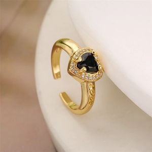 Macro shot of gold heart ring with black stone and Love engraving detail