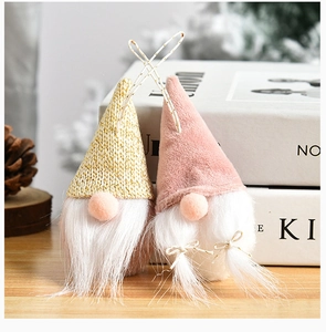 Pink velvet and gold knit Christmas gnomes ornaments on a wooden table setup