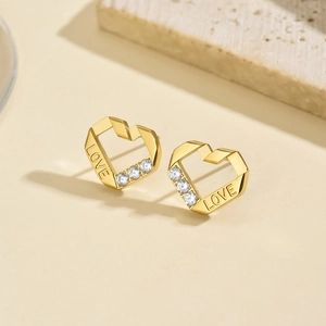 Macro di orecchini a cuore dorati con incisione LOVE e strass luminosi e brillanti