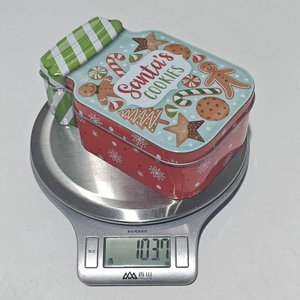 Weight measurement of a Christmas Santa's Cookies tin box on a digital kitchen scale