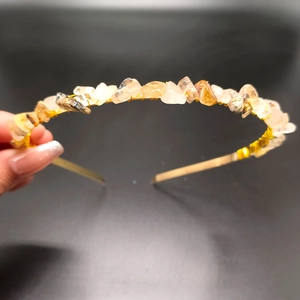Detail of gold wire-wrapped natural crystal shards on a festive bridal headband accessory