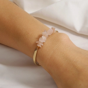 Detail of pink crystal stones hand-wrapped with gold wire on an open cuff bracelet
