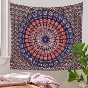 Détail d'une tapisserie mandala bleu foncé et terre cuite sur un mur clair