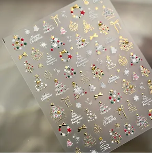 Close-up of 5D embossed Christmas nail stickers featuring gold trees and stars