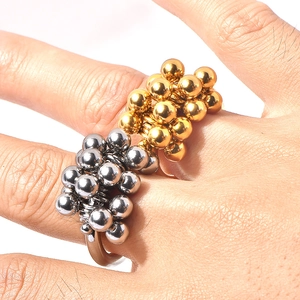 Macro shot of tiered gold and silver metal beads cluster ring on model finger