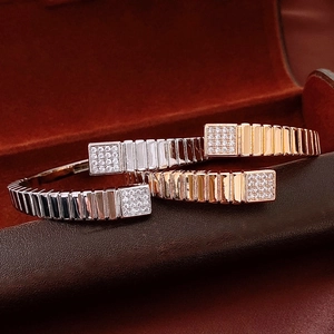 Detail showing gold and silver square bracelets with pave set diamonds in a leather box