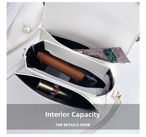 Internal capacity of the white owl bag showing three compartments and a zipper pocket