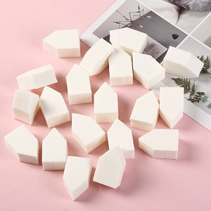 Set of 10 white house-shaped hydrophilic non-latex makeup sponges on pink background