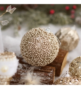 Detailed view of champagne gold beaded Christmas ball ornament with luxury dior brand texture