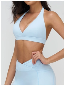 Dettaglio dei leggings da yoga azzurri con vita incrociata e reggiseno sportivo a V