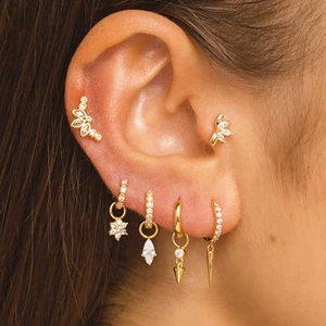Close-up of S925 silver gold tassel butterfly earrings worn on multiple ear piercings