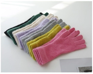 Detailed stack of colorful knit winter gloves showing variety of soft pastel shades