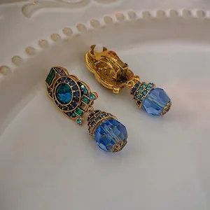 Vintage style bronze ear clips with blue teardrop crystals and emerald rhinestones