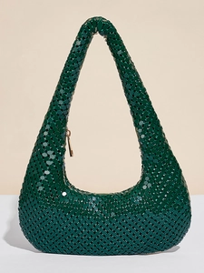 Detail of emerald green metal sequin mesh on a luxury evening handbag with gold zipper