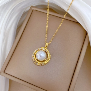 Rotating bird nest pendant necklace with gold plating and pearl on silk fabric
