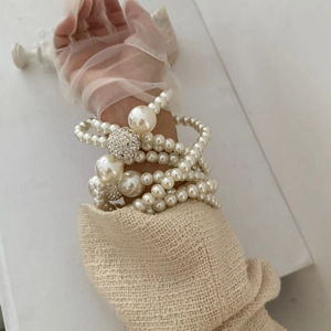 Detail of layered pearl necklace with shimmering crystal ball and vintage French elegance