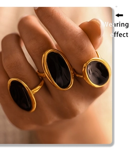 Macro detail of French retro gold PVD plated ring with black oval drip oil inlay on finger