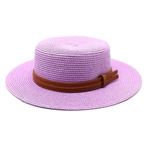 Detailed texture of light purple woven straw boater hat with a brown leather decorative band