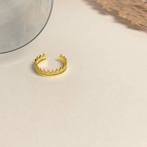 Close-up of a golden double-layered crown ring with cubic zirconia stones