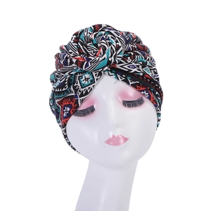 Detail of bohemian turban hat featuring geometric prints and top flower knot design