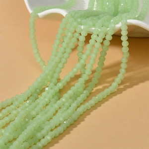 Cuentas facetadas verde claro de 4mm para creación de joyas DIY en un plato de cerámica