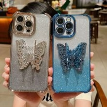Detail of glitter phone cases with 3D butterfly ornaments for Samsung S23 Ultra in a cafe