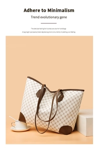 Detail of cream tote bag with chain pattern, brown leather trim and slim handles