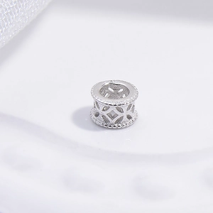 Macro shot of silver hollow-out wheel bead with vintage pattern for jewelry making