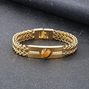 Détail du bracelet en acier titane doré avec pierre œil de tigre et zircons blancs