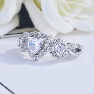 Elegant silver heart-shaped engagement ring with micro-pave diamonds on white roses